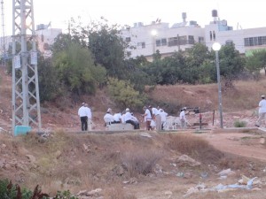 I coloni in preghiera sul terreno della famiglia Jabari