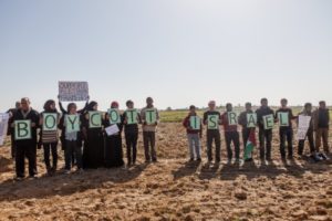attivisti palestinesi e internazionali con cartelli a sostegno del Boicottaggio, Disinvestimento e Sanzioni (BDS)  manifestazione nella zona cuscinetto a Zeitoun, il 9 febbraio 2013. (Foto di Desde Palestina) 