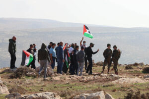 I soldati israeliani cercano di disperdere i palestinesi mentre protestano contro un nuovo avamposto vicino al villaggio di al-Mughayyer, nella Cisgiordania occupata, il 18 dicembre 2020 (Sharona Weiss / Activestills.org)
